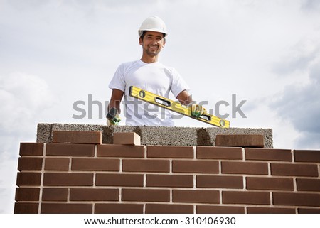 Portrait of construction bricklayer worker against sky.