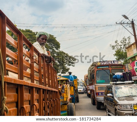 THANJAVOUR, INDIA - FEBRUARY 13: An unidentified Indian man stands in the truck at the traffic congestion  rural road. India, Tamil Nadu, near Thanjavour. February 13, 2013
