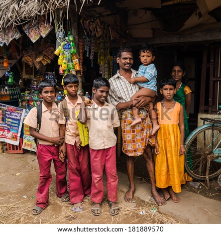 THANJAVUR, INDIA - FEBRUARY 13: An unidentified school children in uniform and man with child standing near rural shop. India, Tamil Nadu, near Thanjavur. February 13, 2013