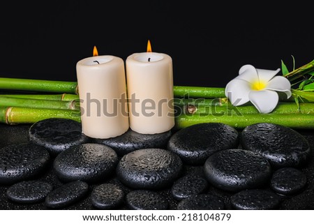 spa concept of zen basalt stones, white flower plumeria, candles and natural bamboo with dew