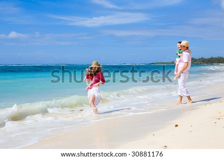 Family vacation. Young family of four on white sand tropical beach