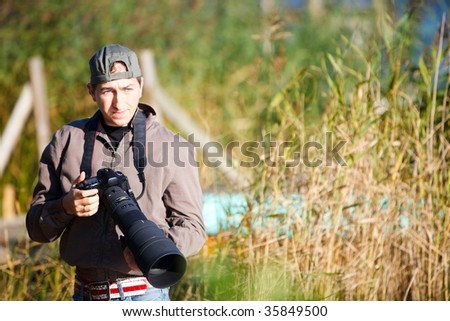 Young nature photographer with taking photos using telephoto lens