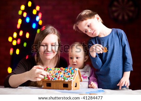 Family decorating gingerbread house on Christmas eve