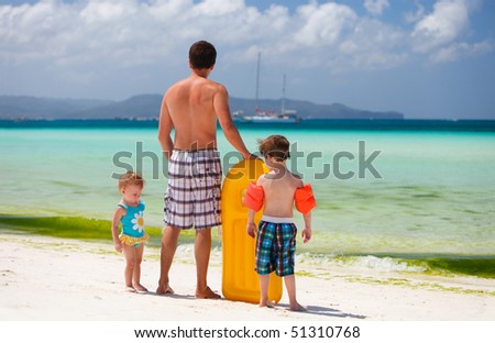 Happy father with his two kids on tropical beach vacation
