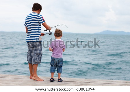 Back view of father and son fishing on summer day