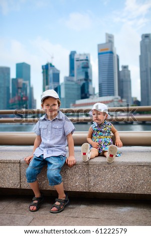 Two kids in big modern city with skyscrapers on background