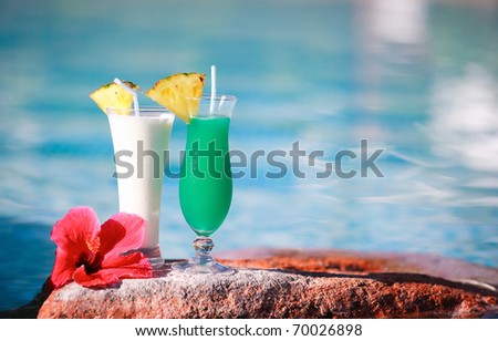Closeup of two tropical cocktails near water