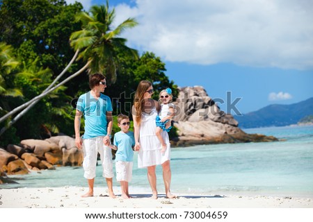 Portrait of happy young family with two kids on tropical vacation