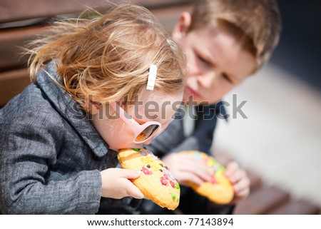 Portrait of two kids eating big cookies