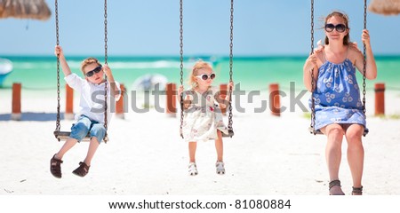 Family swinging with tropical beach on background