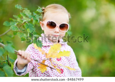 Cute little girl in a park at sunny fall day