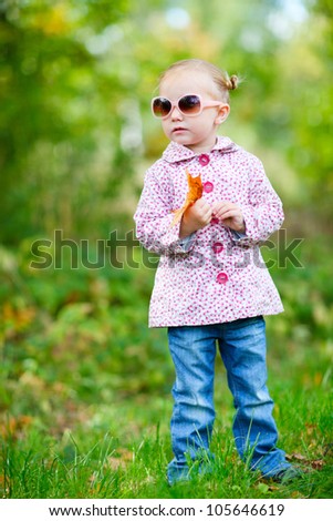 Cute little girl in a park on sunny fall day