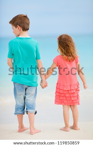 Back view of two small kids at exotic beach