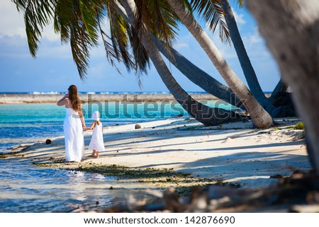 Back view of mother and daughter on a deserted island