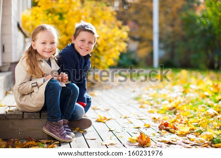 Brother and sister outdoors at beautiful autumn day