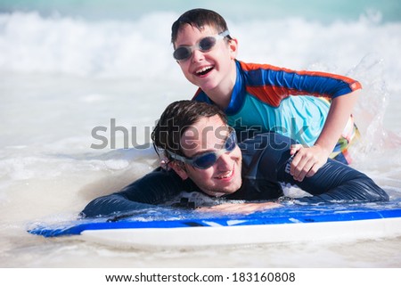 Father and son surfing on boogie boards
