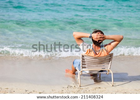 Back view of a man relaxing at tropical beach