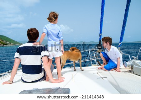 Father, kids and their pet dog sailing on a luxury yacht or catamaran boat