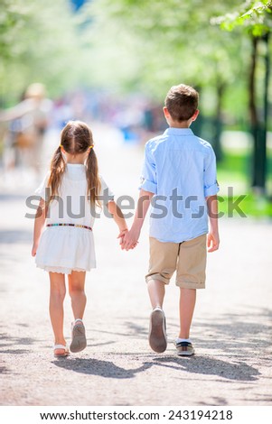 Brother and sister outdoors in a beautiful park at spring day