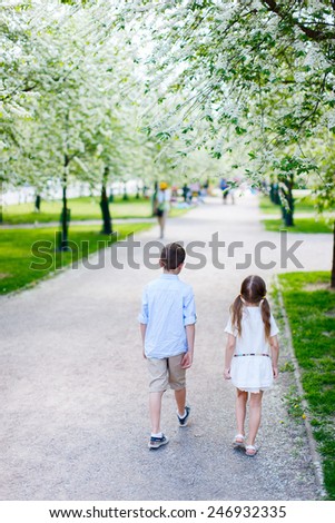 Brother and sister outdoors in a beautiful park on spring day