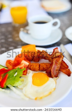 Delicious breakfast with fried eggs, bacon and vegetables