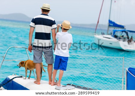 Father, son and their pet dog sailing on a luxury yacht or catamaran boat