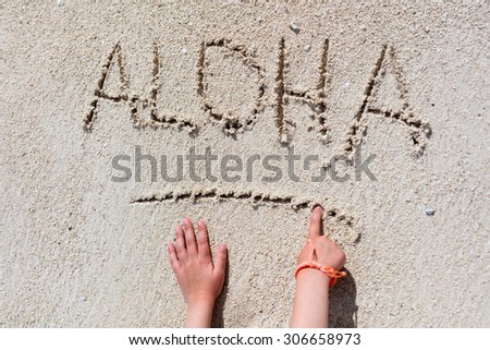 ALOHA word written on tropical sand beach