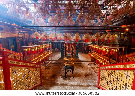 Interior of Man Mo Temple in Hong Kong with incense offerings and coils suspended from the ceiling