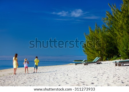 Mother and kids family at tropical beach on Aitutaki island, Cook Islands, South Pacific