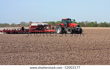 Farm tractor working in a field tilling the soil