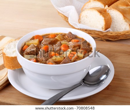 Bowl of vegetable beef soup with sliced bread