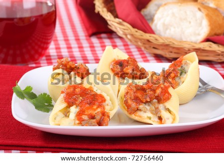 Stuffed pasta shells topped with tomato sauce with wine and bread