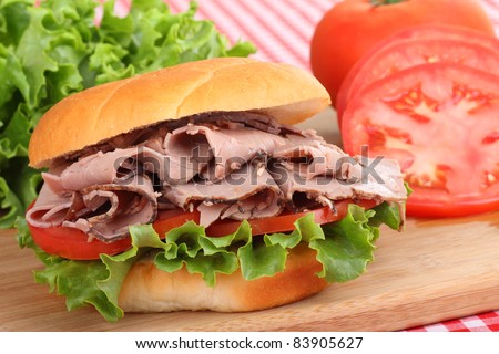 Closeup of a roast beef sandwich with lettuce and tomato
