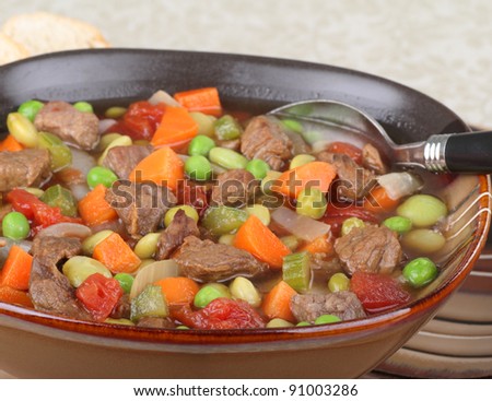 Closeup of a brown bowl of vegetable beef soup