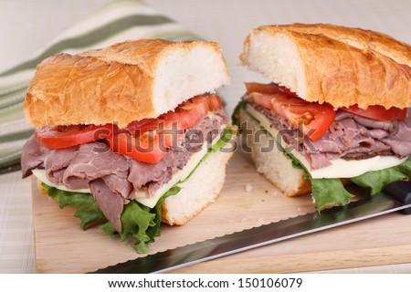 Roast beef sandwich with lettuce, tomato and cheese on french bread