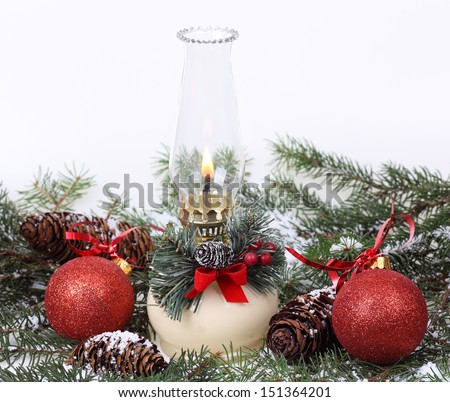Christmas oil lamp with balls and pine cones on a white background