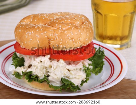 Chicken salad, lettuce and tomato on a sesame seed bun