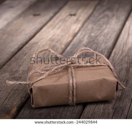 Small brown package wrapped with string on old wood boards