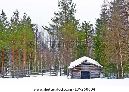 a little hut with snow cover on the roof in forest