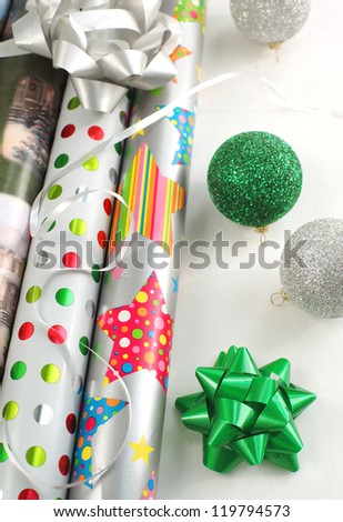 Christmas gift wrapping papers with ribbon and supplies.