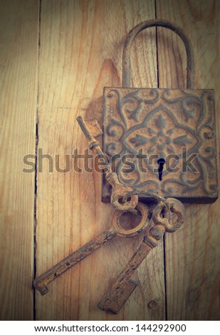 Old decoration lock and keys on wooden background