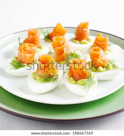 Stuffed eggs. Hard boiled eggs with avocado filling and smoked salmon