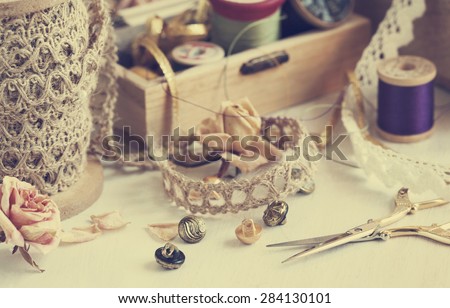 Tools for needlework, thread for sewing, scissors, buttons and vintage laces. Toned image