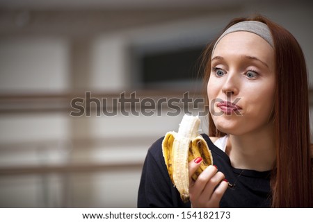 Woman eating banana at the gym for energy