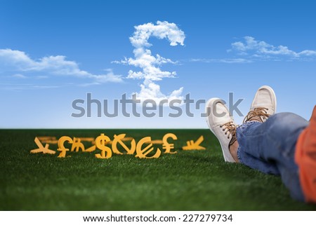 Rich and successful young man is sitting with money on grass