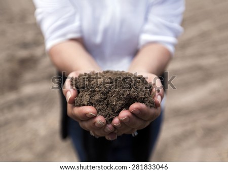 Brown rich soil in hands from agricultural area