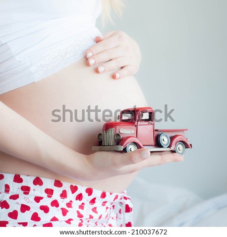 Pregnant Woman plays with a tinny little toy car
