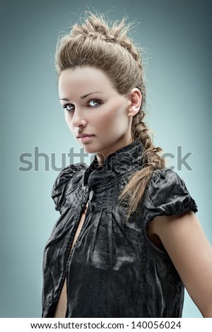 Fashion model posing  in the studio with hairstyle in a black short blouse. Styling.