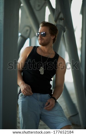 the man in a black vest on the street in iron pipes