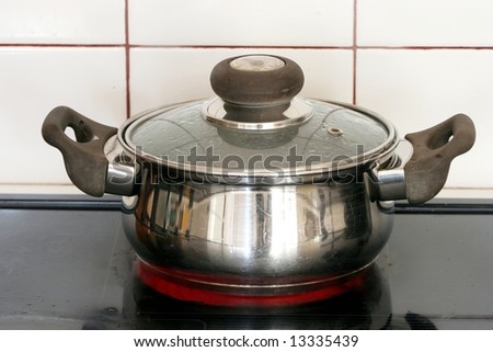 Stainless steel pot on a hot plate of a stove